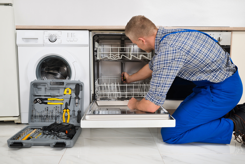 Technician repairing a dishwasher