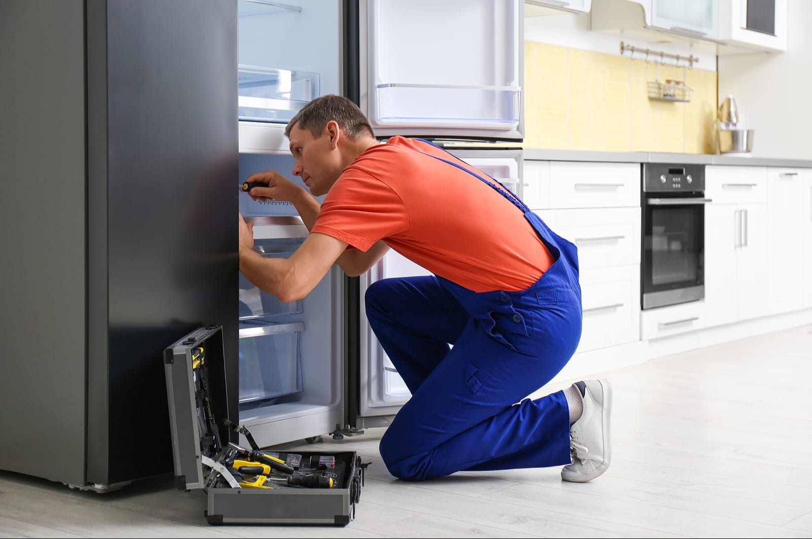Technician servicing a refrigerator