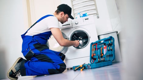 Technician repairing a front-load washing machine