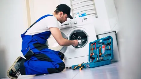 Technician repairing a front-load washing machine
